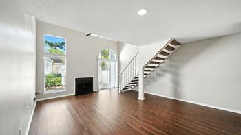 A room with a staircase and a fireplace.